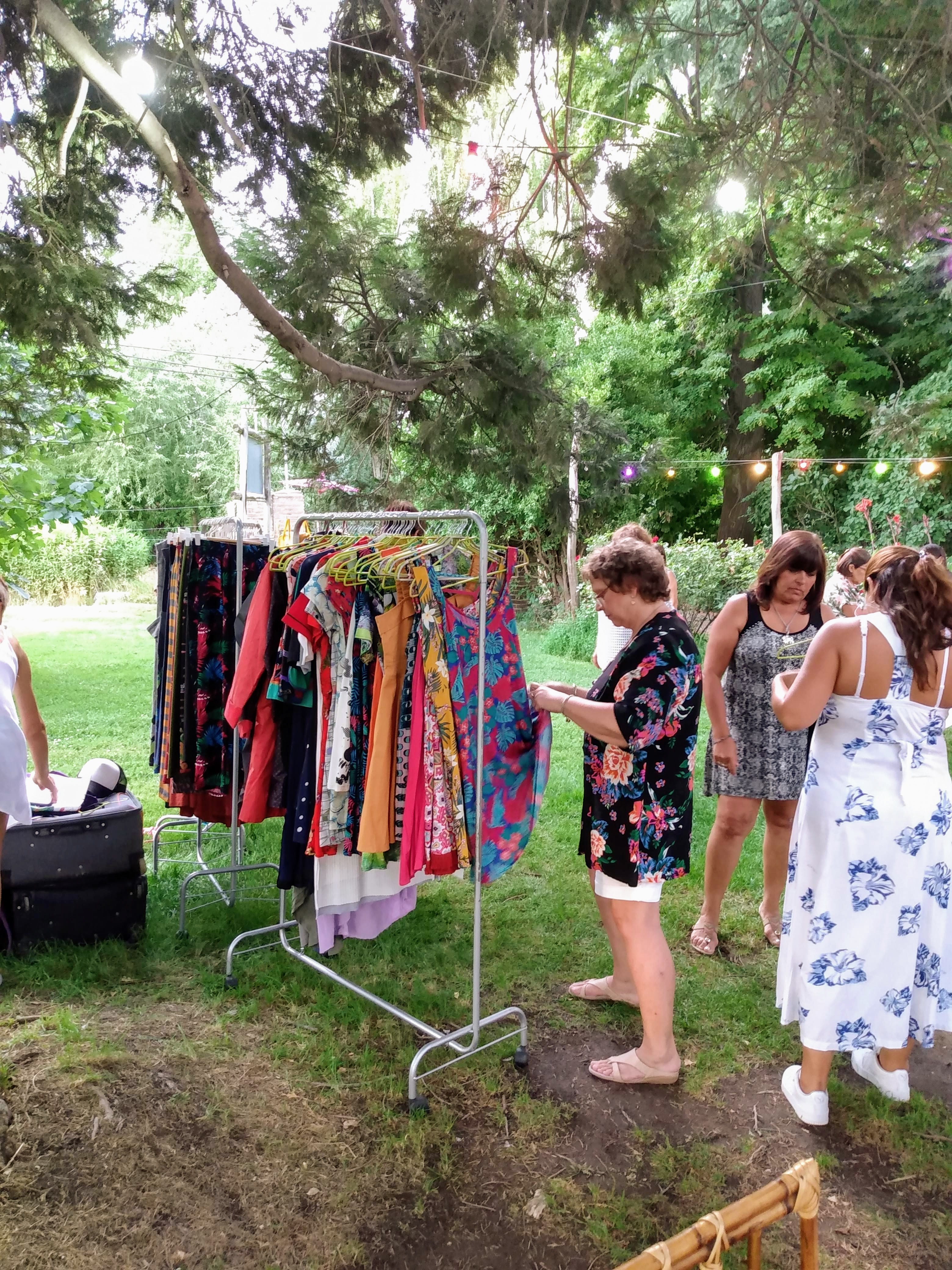 Mujer viendo ropa colgada en un perchero de un stand